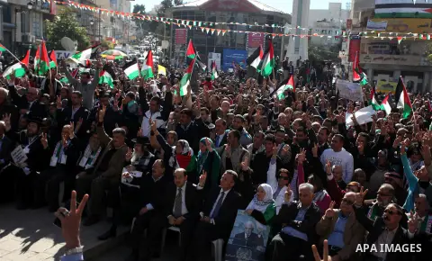 Palestinians wave their national flag during a rally in the West Bank city of Ramallah on November 29, 2012 to support Palestinian leader Mahmud Abbas who is heading to the United Nations General Assembly today with huge...