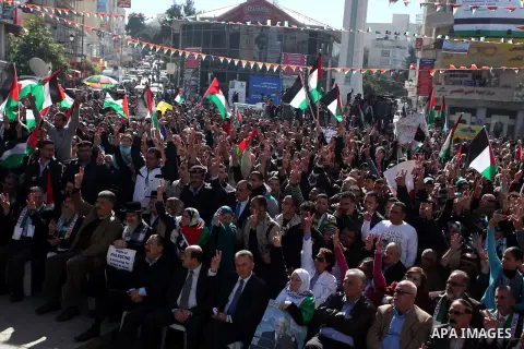 Palestinians wave their national flag during a rally in the West Bank city of Ramallah on November 29, 2012 to support Palestinian leader Mahmud Abbas who is heading to the United Nations General Assembly today with huge...