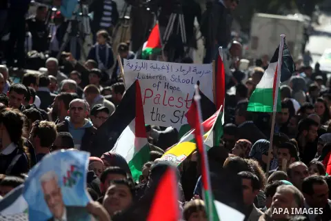 Palestinians wave their national flag during a rally in the West Bank city of Ramallah on November 29, 2012 to support Palestinian leader Mahmud Abbas who is heading to the United Nations General Assembly today with huge...