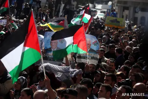 Palestinians wave their national flag during a rally in the West Bank city of Ramallah on November 29, 2012 to support Palestinian leader Mahmud Abbas who is heading to the United Nations General Assembly today with huge...