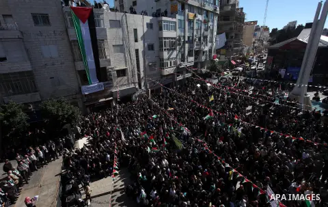 Palestinians wave their national flag during a rally in the West Bank city of Ramallah on November 29, 2012 to support Palestinian leader Mahmud Abbas who is heading to the United Nations General Assembly today with huge...
