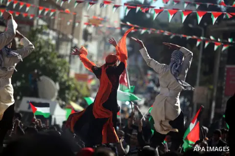 Palestinians perform traditional dance during a rally in the West Bank city of Ramallah on November 29, 2012 to support Palestinian leader Mahmud Abbas who is heading to the United Nations General Assembly today with hug...