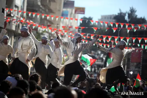 Palestinians perform traditional dance during a rally in the West Bank city of Ramallah on November 29, 2012 to support Palestinian leader Mahmud Abbas who is heading to the United Nations General Assembly today with hug...