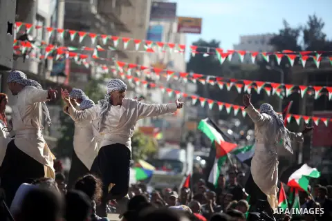 Palestinians perform traditional dance during a rally in the West Bank city of Ramallah on November 29, 2012 to support Palestinian leader Mahmud Abbas who is heading to the United Nations General Assembly today with hug...