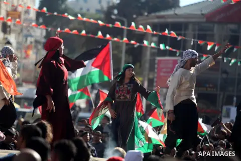 Palestinians perform traditional dance during a rally in the West Bank city of Ramallah on November 29, 2012 to support Palestinian leader Mahmud Abbas who is heading to the United Nations General Assembly today with hug...