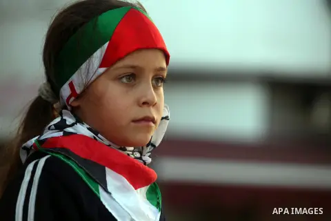 A Palestinian girl with a national flag participate in rally in the West Bank city of Ramallah on November 29, 2012 to support Palestinian leader Mahmud Abbas who is heading to the United Nations General Assembly today w...
