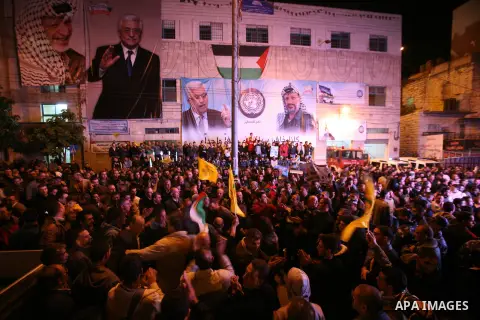 Palestinians wave their national flag during the speech of President Mahmoud Abbas in the U.N. General Assembly, in the West Bank city of Hebron, November 29, 2012. The 193-nation U.N. General Assembly overwhelmingly app...