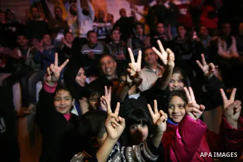 Palestinians flash victory sign during the speech of President Mahmoud Abbas in the U.N. General Assembly, in the West Bank city of Hebron, November 29, 2012. The 193-nation U.N. General Assembly overwhelmingly approved...