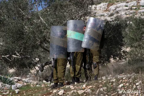 Israeli soldiers take cover during clashes on the sidelines of a demonstration against the expropriations by Israel in the West Bank village of Kafr Qaddum, near Nablus, on November 30, 2012. Photo by Nedal Eshtayah