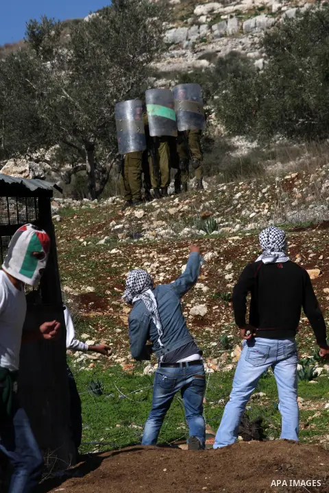 Palestinians throw stones to Israeli soldiers on the sidelines of a demonstration against the expropriations by Israel in the West Bank village of Kafr Qaddum, near Nablus, on November 30, 2012. Photo by Nedal Eshtayah