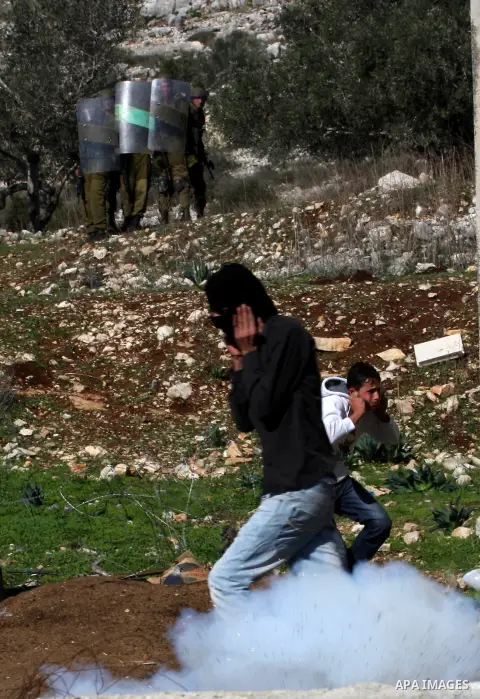 Palestinians throw stones to Israeli soldiers on the sidelines of a demonstration against the expropriations by Israel in the West Bank village of Kafr Qaddum, near Nablus, on November 30, 2012. Photo by Nedal Eshtayah