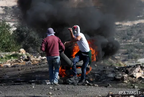 Palestinian protesters burn a tire on the sidelines of a demonstration against the expropriations by Israel in the West Bank village of Kafr Qaddum, near Nablus, on November 30, 2012. Photo by Nedal Eshtayah