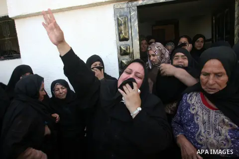 Palestinian relatives mourn over the body of Mahmoud Jarghoun, 21, during his funeral in the town of Rafah in the southern Gaza Strip on December 1, 2012. One Palestinian died and another was wounded when an Israeli miss...