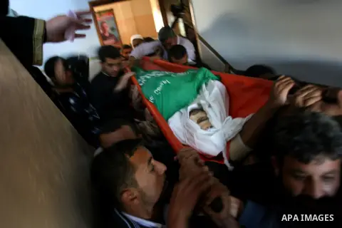 Palestinians carry the body of Mahmoud Jarghoun, 21, during his funeral in the town of Rafah in the southern Gaza Strip on December 1, 2012. One Palestinian died and another was wounded when an Israeli missile fired days...