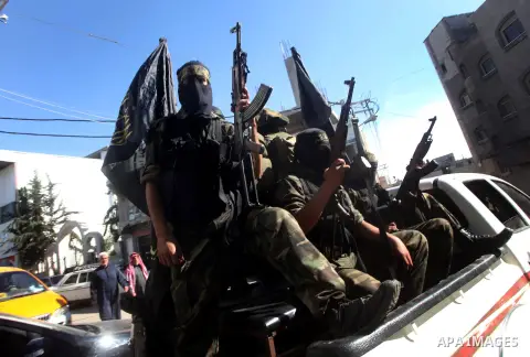Islamic Jihad militants take part in the funeral of their comrade Ramadan Abu Hassanein during his funeral in Bureij refugee camp in the central Gaza Strip on Dec. 01, 2012. Abu Hassanein died from a wound he suffered fr...