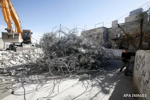 An Israeli bulldozer destroys a home in East Jerusalem district of Sur Baher on December 1, 2012 after an Israeli court ruled that the house was built without a municipality permit. Many Palestinians end up demolishing t...