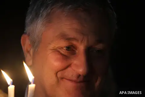 A Foreign activist holds a candle during a solidarity march with the Dalu family next to their house, as well as a wrecked car festooned with candles, which was hit by an Israeli strike during Israel's recent military of...