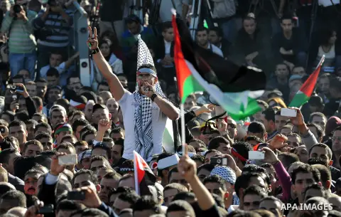 Palestinians wave national flags as they celebrate their successful bid for UN non-member observer state status, in the West Bank city of Ramallah on December 2, 2012, Palestinian President Mahmoud Abbas arrived to the W...