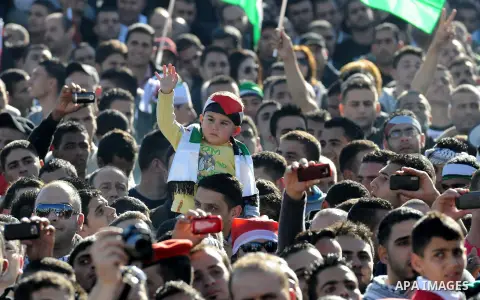 Palestinians wave national flags as they celebrate their successful bid for UN non-member observer state status, in the West Bank city of Ramallah on December 2, 2012, Palestinian President Mahmoud Abbas arrived to the W...