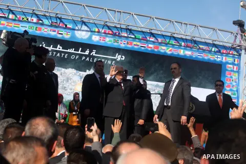 Palestinian President Mahmoud Abbas gestures as Palestinians celebrate their successful bid for UN non-member observer state status, in the West Bank city of Ramallah on December 2, 2012, Abbas arrived to the West Bank a...