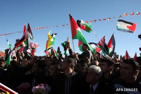 Palestinians wave national flags as they celebrate their successful bid for UN non-member observer state status, in the West Bank city of Ramallah on December 2, 2012, Palestinian President Mahmoud Abbas arrived to the W...