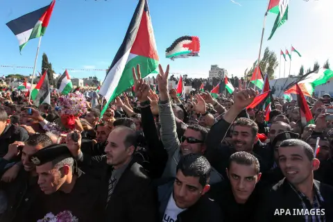Palestinians wave national flags as they celebrate their successful bid for UN non-member observer state status, in the West Bank city of Ramallah on December 2, 2012, Palestinian President Mahmoud Abbas arrived to the W...