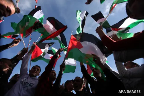 Palestinians wave national flags as they celebrate their successful bid for UN non-member observer state status, in the West Bank city of Ramallah on December 2, 2012, Palestinian President Mahmoud Abbas arrived to the W...