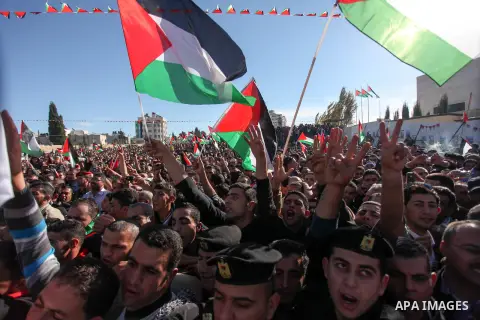 Palestinians wave national flags as they celebrate their successful bid for UN non-member observer state status, in the West Bank city of Ramallah on December 2, 2012, Palestinian President Mahmoud Abbas arrived to the W...