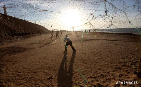 Palestinian youths play football at the beach in Gaza City on December 2, 2012. As part of the truce that ended eight days of cross-boarder fighting between Israel and Gaza militants, Israel's naval blockade of the coast...