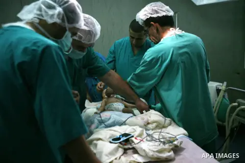 Palestinian and foreign doctors gather around a child who suffer from harelip and cleft palate during surgery operation at Hebron Governmental Hospital in the West Bank city of Hebron on December 2,2012. . Photo by Mamou...