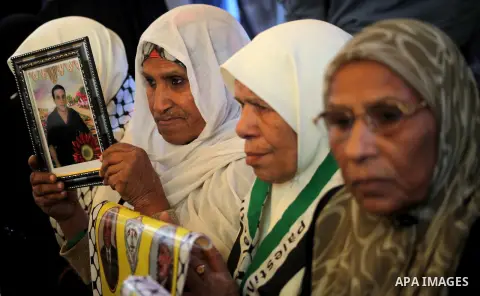 Palestinian women hold pictures of their prisoned relatives in Israeli jails as they gather in a weekly activity calling for their liberty at the Red Cross headquarters in Gaza City on December 03, 2012. Photo by Ashraf...