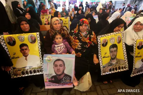 Palestinians hold pictures of their prisoned relatives in Israeli jails as they gather in a weekly activity calling for their liberty at the Red Cross headquarters in Gaza City on December 03, 2012. Photo by Ashraf Amra