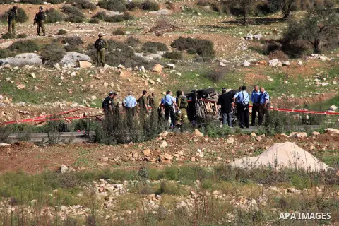 Israeli soldiers inspect the damage cars of Israeli forces from the Shin Bet internal security agency and Hatem Shadid, a Palestinian who was shot dead earlier the agency members after he rammed their car and attacked th...