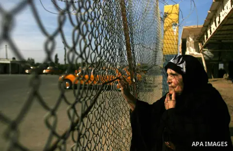 Palestinian relatives of Fatah movement members wait at Rafah crossing border between Gaza strip and Egypt, as they pass the crossing on December 03, 2012. Hamas movement allowed to Fatah members to enter Gaza Strip afte...