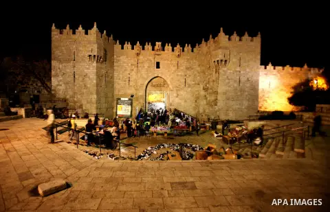 Palestinians walk at Damascus gate in front of al-Aqsa mosque Islam's third holiest site, in the old city of Jerusalem on December 03, 2012. Photo by Mahfouz Abu Turk