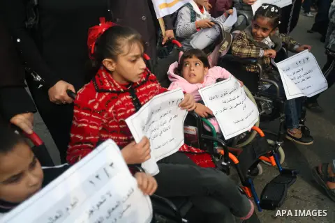 Palestinian children with special needs walk past buildings destroyed during the Gaza-Israeli conflict during a demonstration on the occasion of the UN International Day of People with Disability, on December 4, 2012 in...