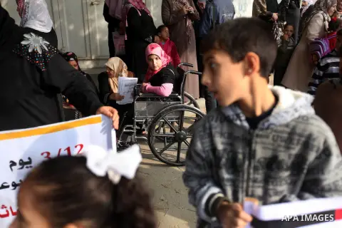 Palestinian children with special needs walk past buildings destroyed during the Gaza-Israeli conflict during a demonstration on the occasion of the UN International Day of People with Disability, on December 4, 2012 in...