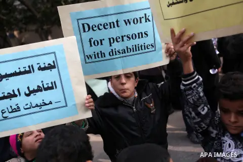 Palestinian children with special needs walk past buildings destroyed during the Gaza-Israeli conflict during a demonstration on the occasion of the UN International Day of People with Disability, on December 4, 2012 in...