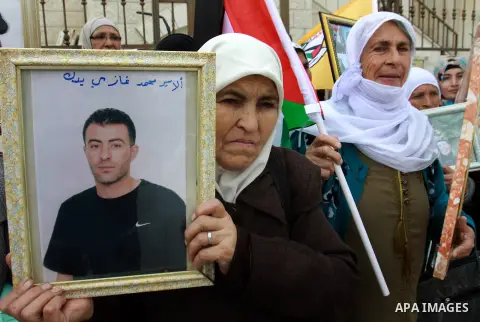 Palestinians hold pictures of their prisoned relatives in Israeli jails as they gather in a weekly activity calling for their liberty at the Red Cross headquarters in the West Bank city of Nablus on December 04, 2012. Ph...