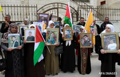 Palestinians hold pictures of their prisoned relatives in Israeli jails as they gather in a weekly activity calling for their liberty at the Red Cross headquarters in the West Bank city of Nablus on December 04, 2012. Ph...