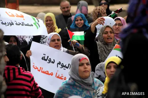 Palestinians hold national flags during a rally to support reconciliation between rival Palestinian factions in Gaza city on 04 Dec, 2012. Palestinian President Mahmud Abbas pledged Sunday to resume efforts at reconcilia...