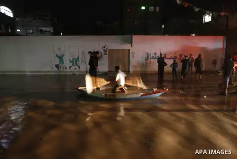 Palestinians walk at a pool of rain water in El-Shati' refugee camp in Gaza city, on Dec. 04, 2011. the onset of winter in the Palestinian territories. Photo by Mahmud Nassar