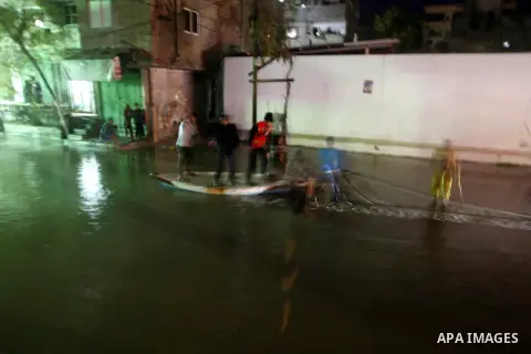 Palestinians walk at a pool of rain water in El-Shati' refugee camp in Gaza city, on Dec. 04, 2011. the onset of winter in the Palestinian territories. Photo by Mahmud Nassar