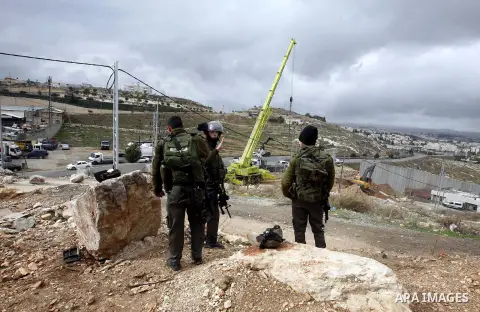 Israeli laborers install concrete sections during the the construction of the separation barrier wall in the Palestinian neighborhood of Shuafat in East Jerusalem, 05 Dec, 2012. Photo by Mahfouz Abu Turk