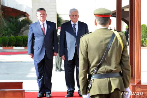 King Abdullah II of Jordan, and Palestinian President Mahmoud Abbas, walk past honor guards prior to their meeting in the West Bank city of Ramallah, Thursday, Dec. 6, 2012. Jordan's King Abdullah II has begun a brief vi...