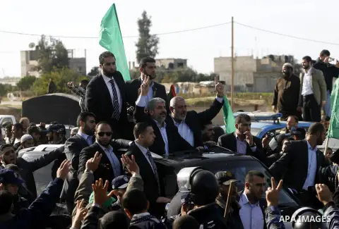 Hamas chief Khaled Meshaal and Palestinian prime minister in the Gaza Strip, Ismail Haniya wave upon Meshaal's arrival in Rafah, southern Gaza, on December 7, 2012. Meshaal is making his first-ever visit to the Gaza Stri...