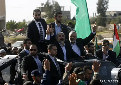 Hamas chief Khaled Meshaal and Palestinian prime minister in the Gaza Strip, Ismail Haniya wave upon Meshaal's arrival in Rafah, southern Gaza, on December 7, 2012. Meshaal is making his first-ever visit to the Gaza Stri...