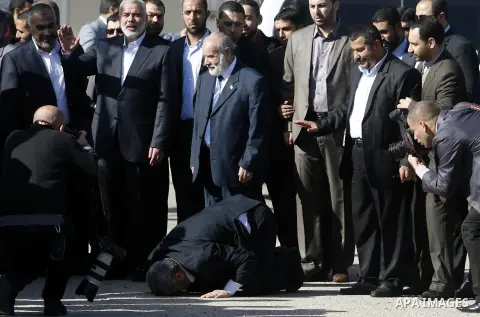 Hamas chief Khaled Meshaal prays, with his head to the ground, upon his arrival in Rafah, southern Gaza, on December 7, 2012. Meshaal is making his first-ever visit to the Gaza Strip amid tight security for festivities m...