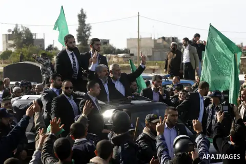 Hamas chief Khaled Meshaal and Palestinian prime minister in the Gaza Strip, Ismail Haniya wave upon Meshaal's arrival in Rafah, southern Gaza, on December 7, 2012. Meshaal is making his first-ever visit to the Gaza Stri...