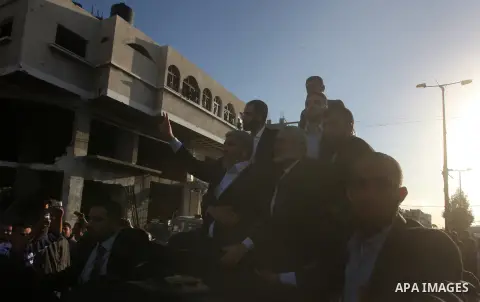 Hamas chief Khaled Meshaal, riding in a car with Palestinian prime minister in Gaza Strip Ismail Haniyeh, waves to the crowd upon his arrival in Gaza City December 7, 2012. Meshaal is making his first-ever visit to the G...